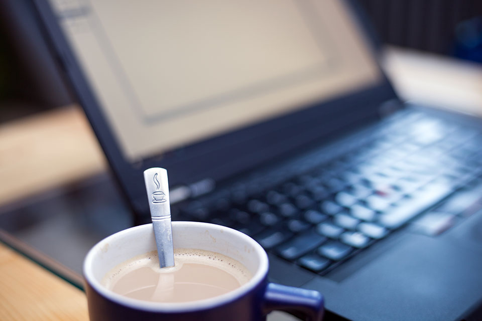 Boekhouder van M-Advisors achter de computer met koffie
